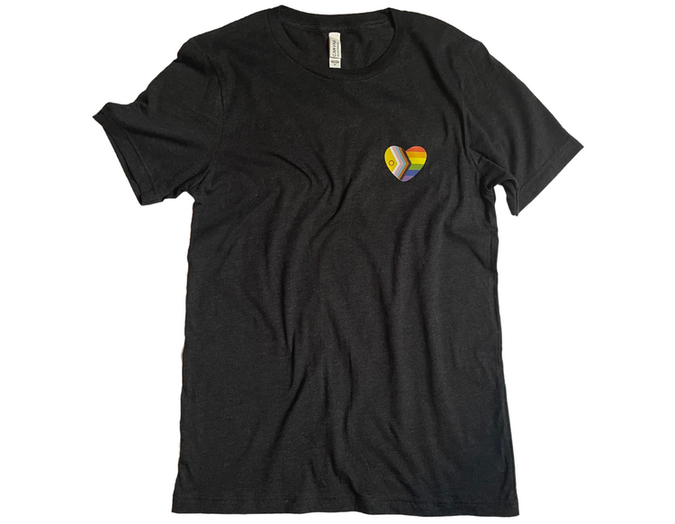Black t-shirt is laid flat against a white background with wrinkles bunched purposefully. A heart shape rainbow flag is placed over the left chest.