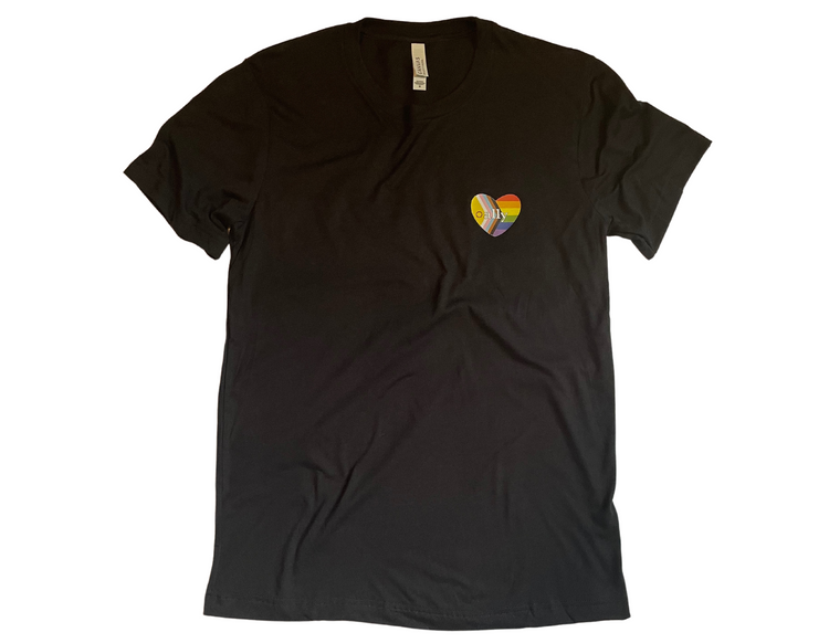 Black t-shirt is laid flat with wrinkles bunched purposefully against a white background. A heart shape rainbow flag is placed over the left chest with the word ally centered amongst it.